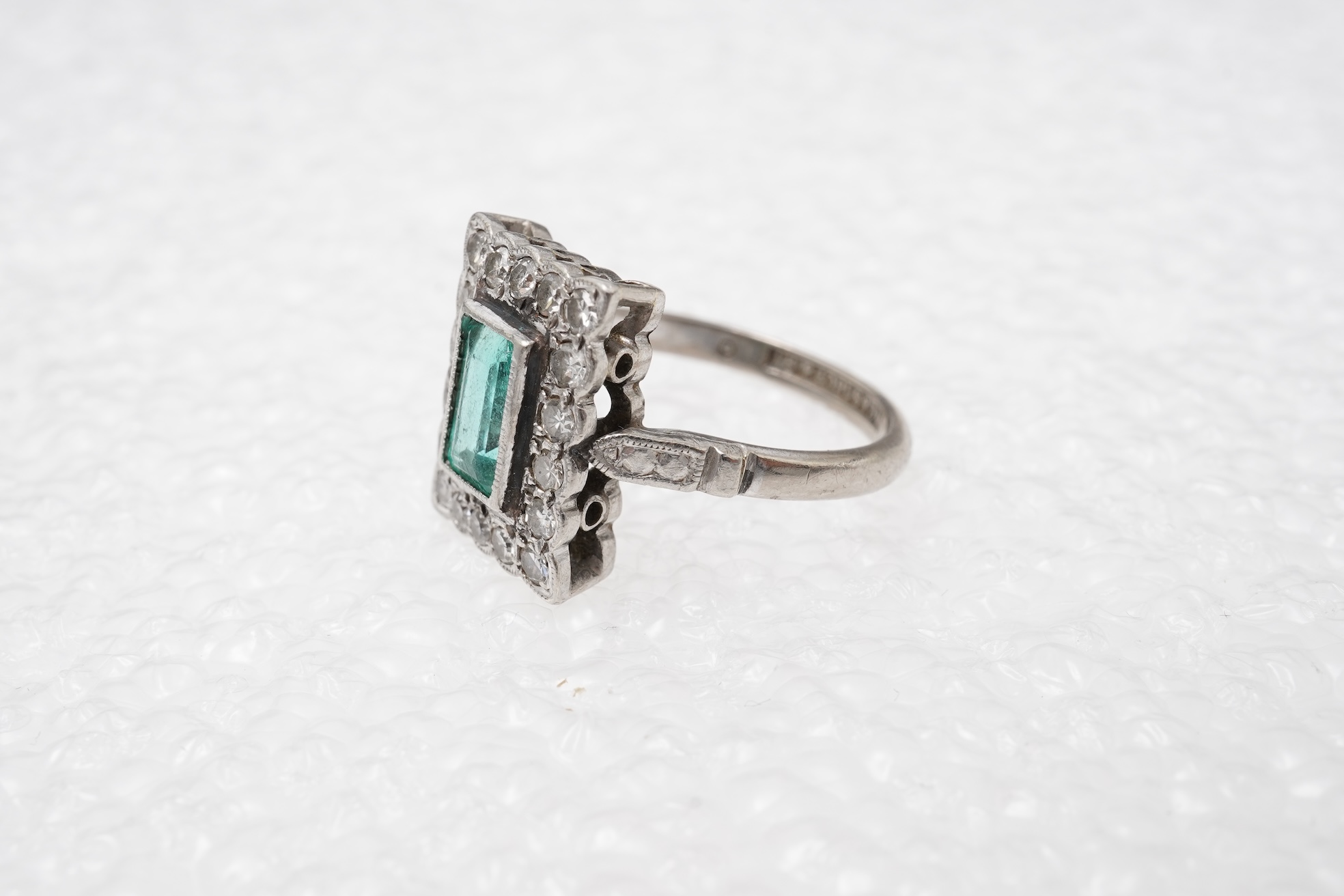 An emerald and diamond cluster ring, first half 20th century